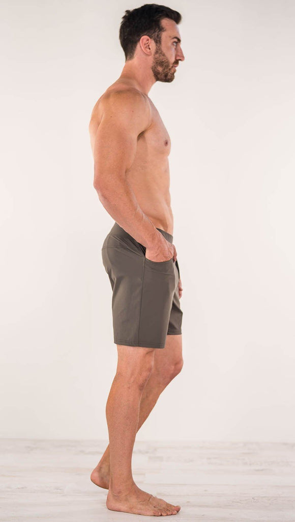 Right side view of model wearing men's taupe performance shorts with slim fit