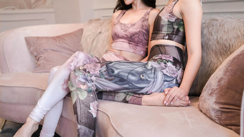 two girls lounging on a couch wearing WERKSHOP. The first girl is wearing the Dark Unicorn Athleisure Set and the second girl is wearing Stella.