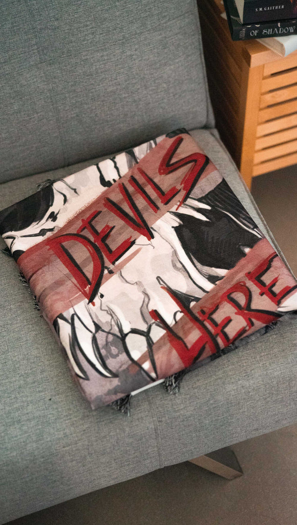 zoomed in image of a decorative blanket with a skull over a distressed background. Featuring the quote, "Hell is Empty and All The Devils Are Here" by William Shakespeare from the play, The Temptest.