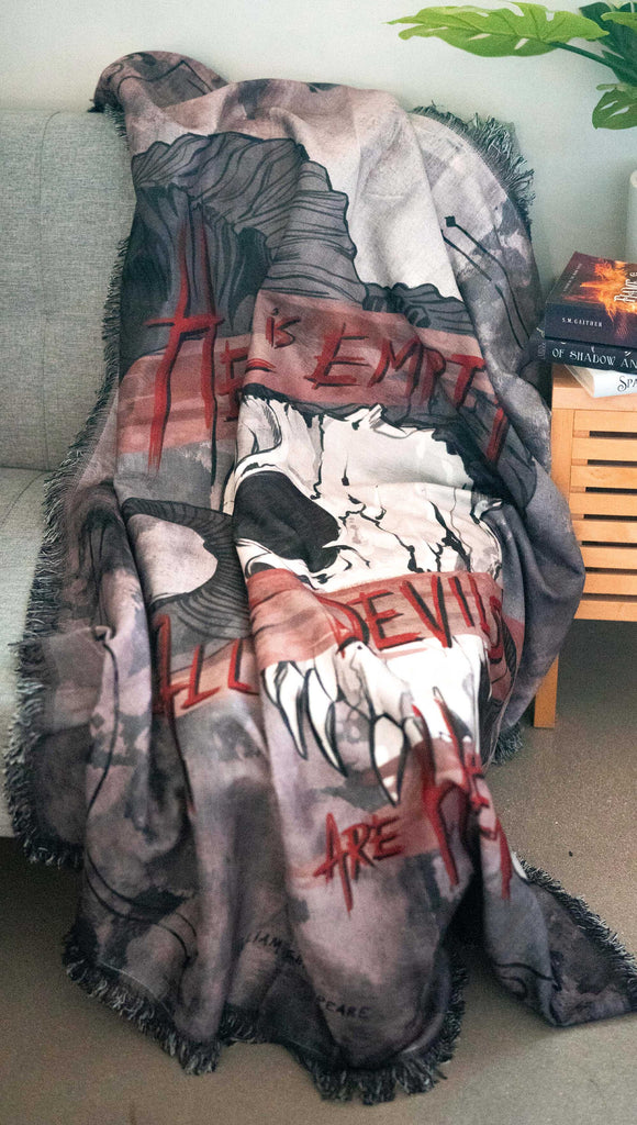 zoomed in image of a decorative blanket with a skull over a distressed background. Featuring the quote, "Hell is Empty and All The Devils Are Here" by William Shakespeare from the play, The Temptest.