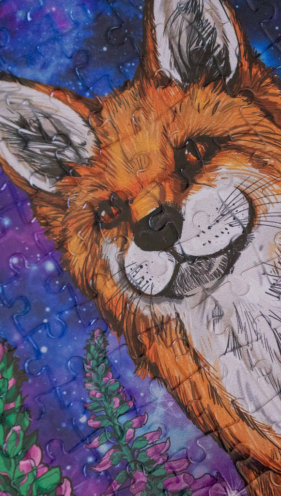 252 piece jigsaw puzzle featuring original artwork of a fox with foxglove in front of a galactic sky. A % of the proceeds benefit Save a Fox Rescue.