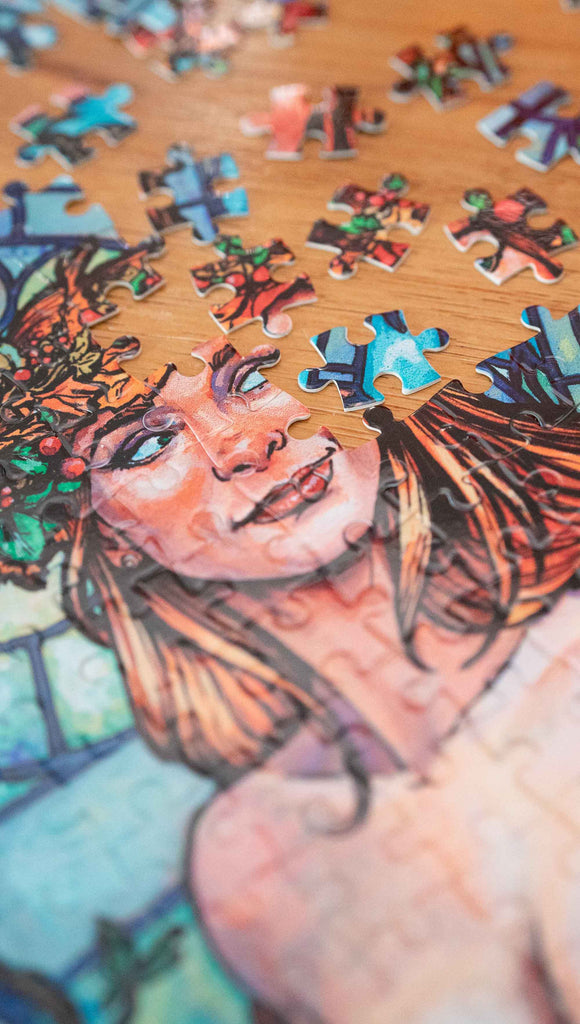 Zoomed in photo of Jana Rose Puzzle by Scott Christian Sava. The image is showing a partially disassembled puzzle. The artwork on the puzzle features a woman with a wreath crown on her head and a bright red dress standing in front of a stained glass window.