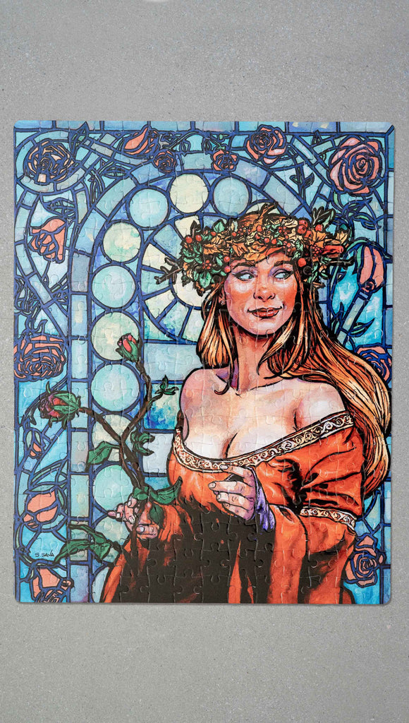 Photo of competed Jana Rose Puzzle by Scott Christian Sava. The artwork on the puzzle features a woman with a wreath crown on her head and a bright red dress standing in front of a stained glass window.