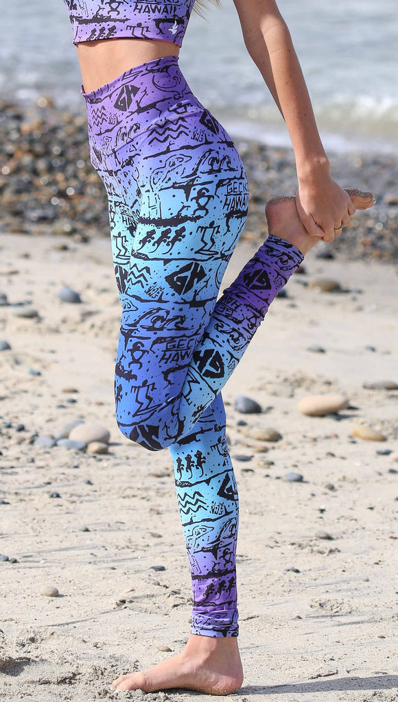 Gecko Hawaii X WERKSHOP "Surf" Collab. This photo shows a model wearing the leggings: featuring iconic Gecko Hawaii artwork in a blue/purple ombre background. 