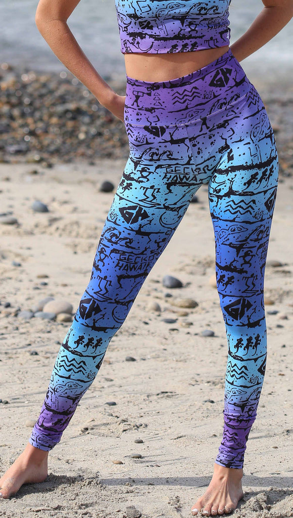 Gecko Hawaii X WERKSHOP "Surf" Collab. This photo shows a model wearing the leggings: featuring iconic Gecko Hawaii artwork in a blue/purple ombre background. 