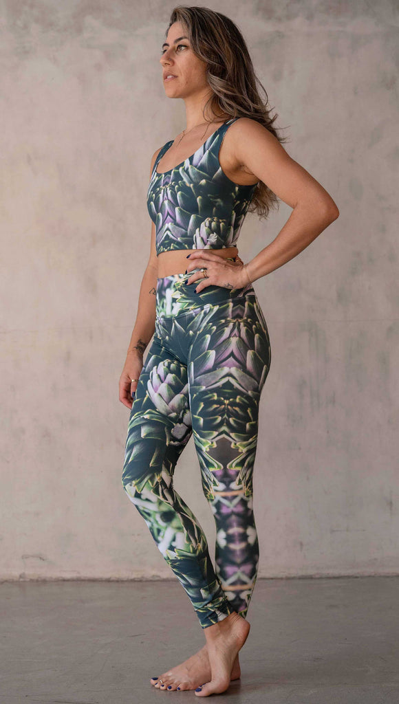 Girl wearing WERKSHOP Artichoke Athleisure Leggings. The leggings show a photo-real fractal inspired edit of artichokes. It has pops of bright green and bright purple over a mostly dark green base. It is a very geometric and fractal design.