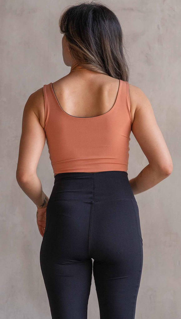 Model wearing WERKSHOP Four Way Reversible Top in EnviSoft Fabric. She is wearing the Toasted Nut side out in this photo with the “X” detail in the front.