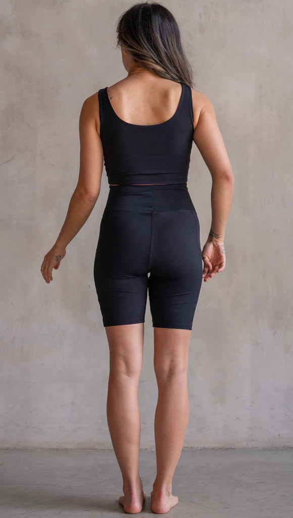 Model wearing WERKSHOP Black EnviSoft Bicycle Length Shorts with Pockets. Featuring flatlock seams and a small eagle logo on the wearer's left thigh.