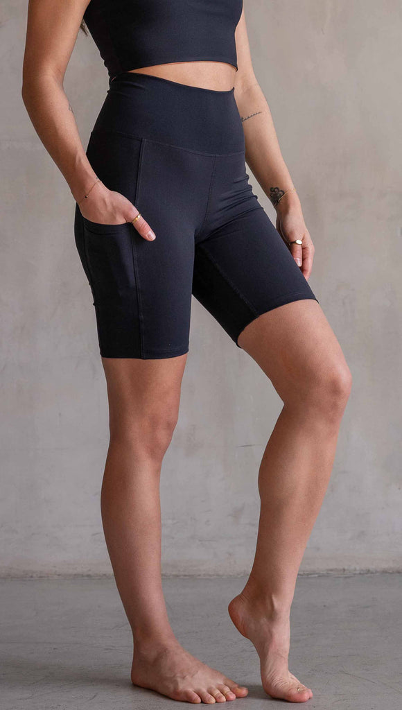 Model wearing WERKSHOP Black EnviSoft Bicycle Length Shorts with Pockets. Featuring flatlock seams and a small eagle logo on the wearer's left thigh.