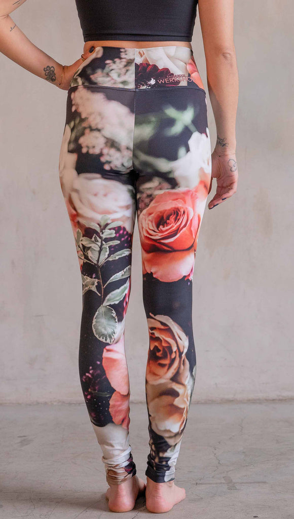 Model wearing WERKSHOP Bodacious Bouquet Athleisure Leggings. The leggings feature a floral bouquet with pink and white roses and leafy greens throughout