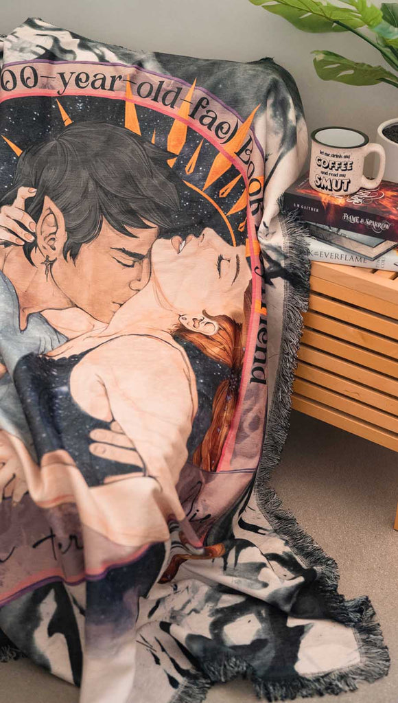 Blanket with an illustration of two people embracing, draped over a surface.