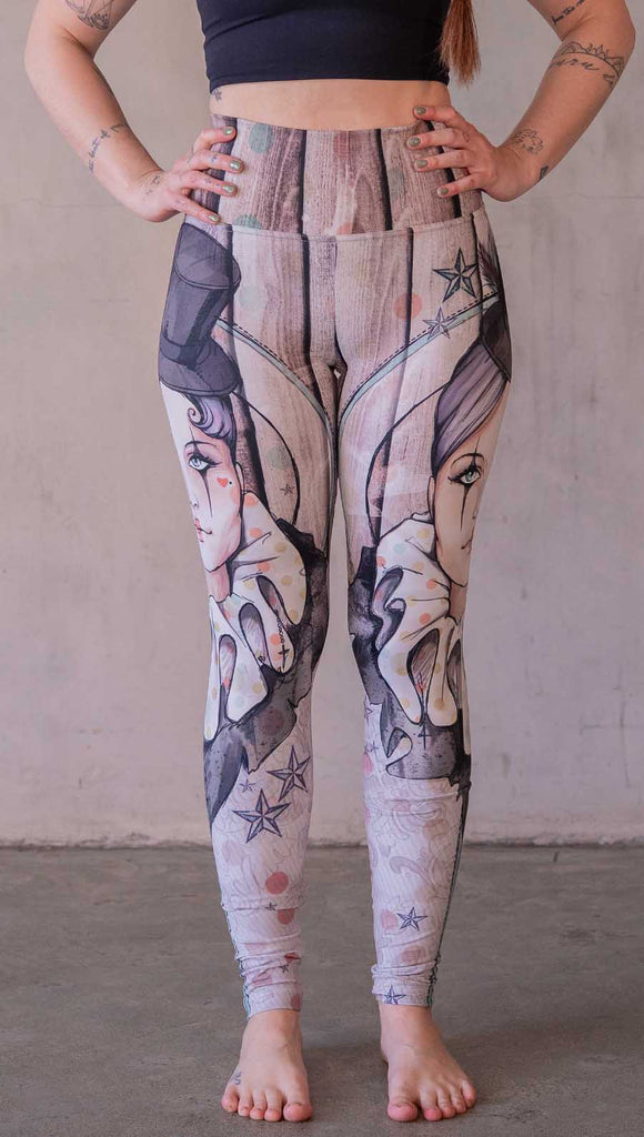 Model wearing WERKSHOP Circus Girl Leggings. Featuring artwork of a circus girl wearing a top hat, ruffled collar with mime makeup over a polka dot and woodgrain background.