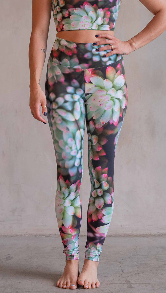 Model wearing WERKSHOP Mojave Sunset Athleisure Leggings. The print on the leggings features photo-real succulents with bright pops of green and hot pink.