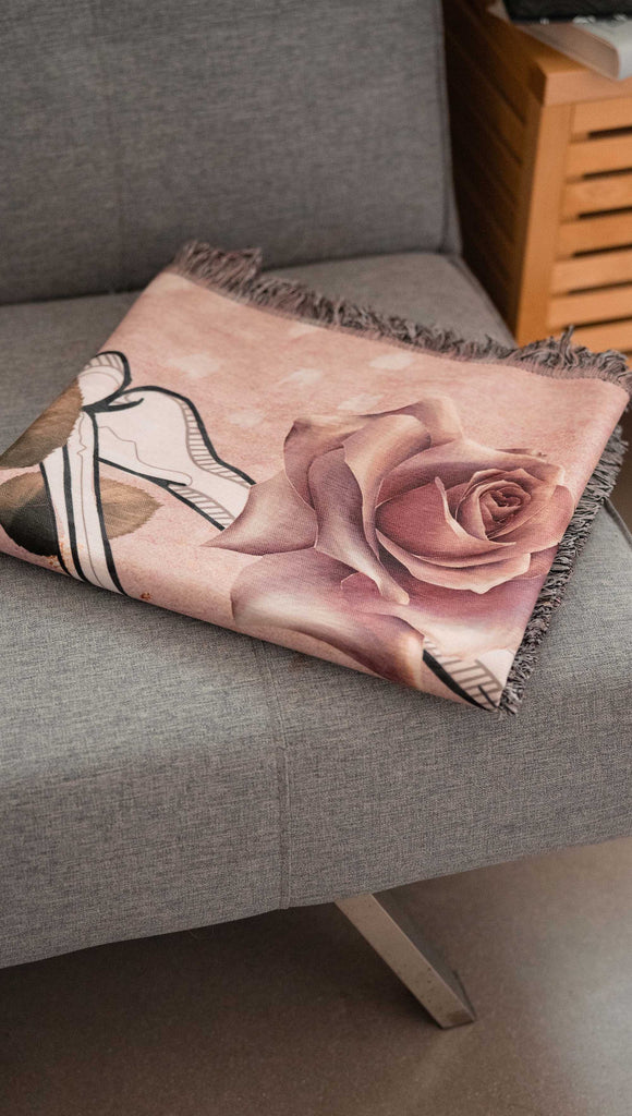 Blanket with a rose design on a gray couch