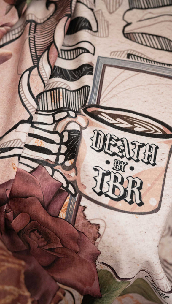 Blanket with a skeleton and floral design on a textured surface. with the phrases, "Death by TBR" and "How to Find Time to Read more Books"