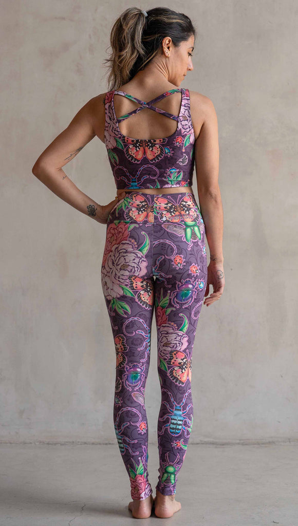 Full body back view of model wearing WERKSHOP Enchanted Garden Athleisure Leggings. The fabric is printed with original artwork by our Female Founder, Chriztina Marie. The artwork printed not the fabric features Butterflies, Beetles and Peonies over a warm fuchsia with bright bold pops of color on each beetle and Butterfly.
