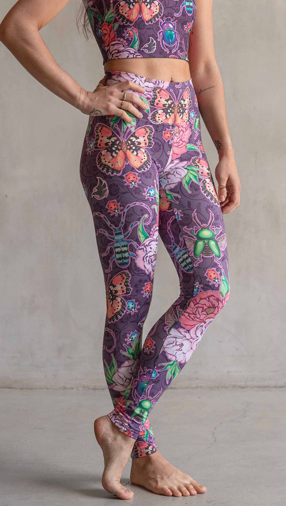 Side view of model wearing WERKSHOP Enchanted Garden Athleisure Leggings. The fabric is printed with original artwork by our Female Founder, Chriztina Marie. The artwork printed not the fabric features Butterflies, Beetles and Peonies over a warm fuchsia with bright bold pops of color on each beetle and Butterfly.