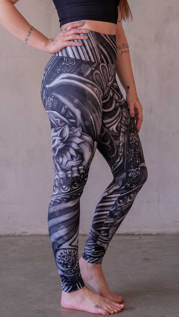 Model wearing WERKSHOP Gargoyle leggings featuring original and exclusive artwork of a black and gray gothic stone gargoyle perched on a ledge.