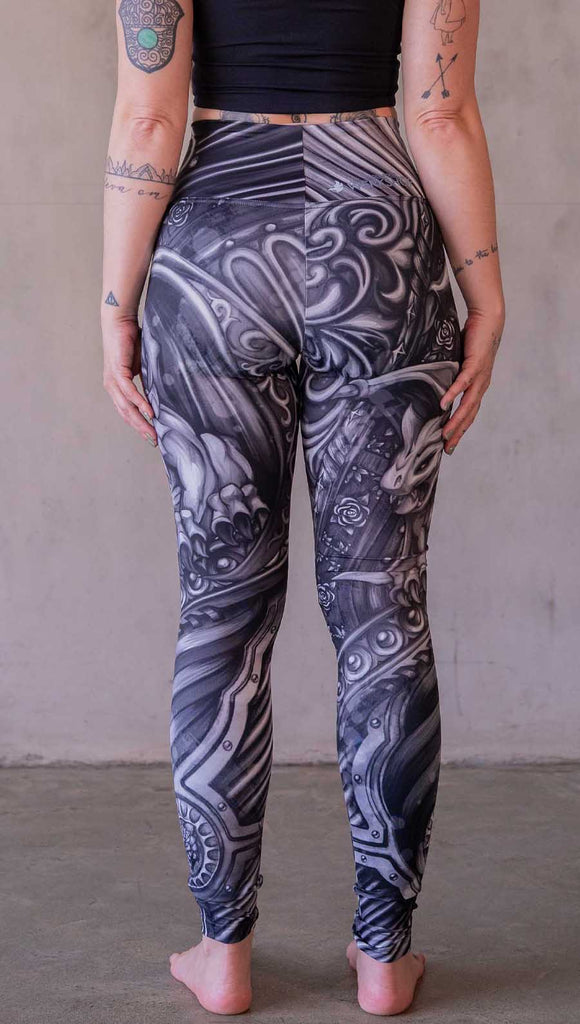 Model wearing WERKSHOP Gargoyle leggings featuring original and exclusive artwork of a black and gray gothic stone gargoyle perched on a ledge.