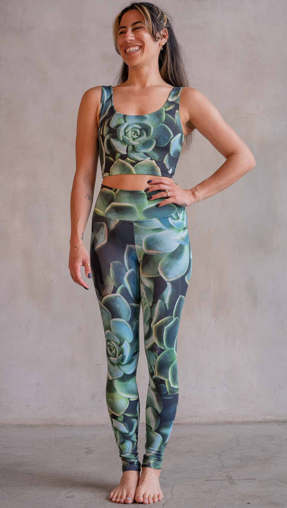 Model wearing WERKSHOP Green Envy Athleisure Leggings. The leggings are printed with a photo-real macro green succulent clusters.