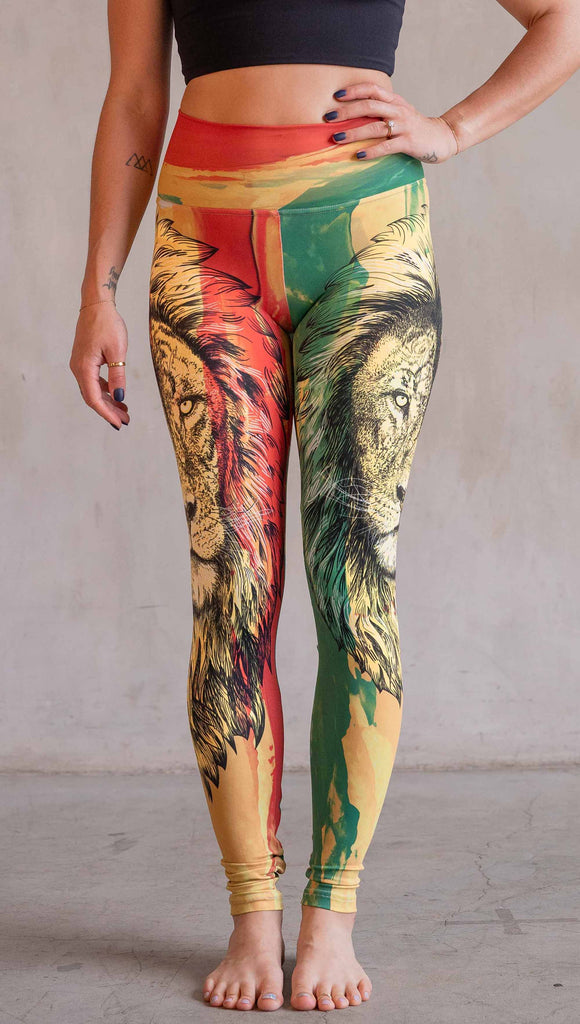 Model wearing WERKSHOP Lion of Zion Athleisure Leggings. The leggings feature a hand illustration of a lion over organic brustrokes in Rastafarian colors.
