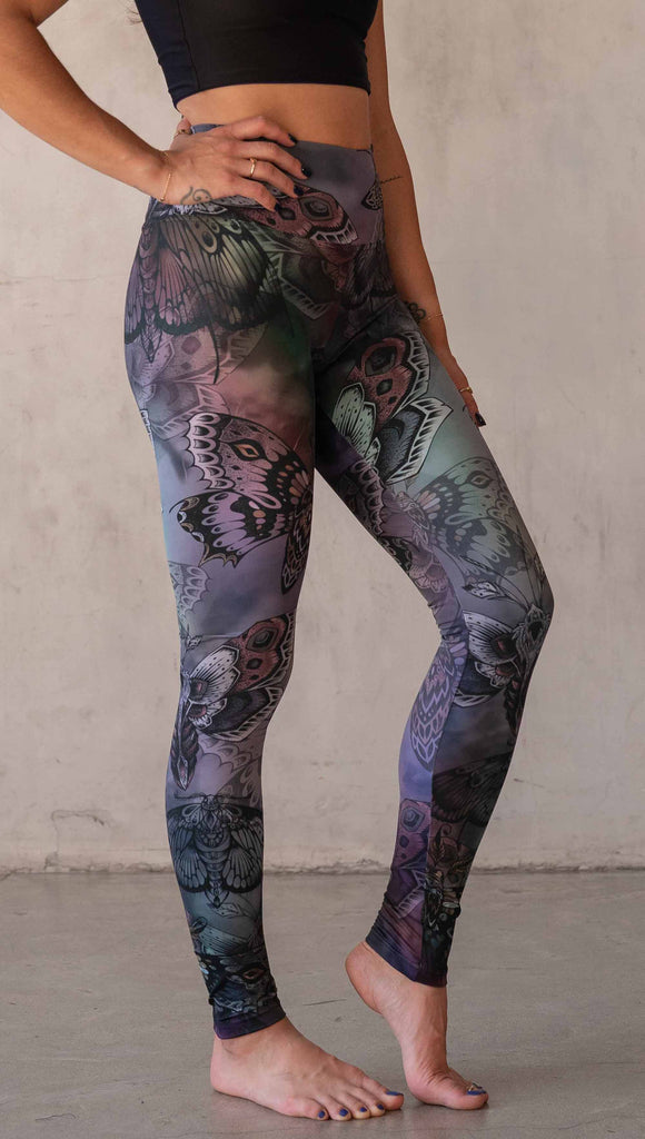 Side view of model wearing WERKSHOP Moths athlisure leggings. The artwork on the leggings is of hand drawn moths with muted pops of mauve and peach over an edgy "oil slick" inspired watercolor background.
