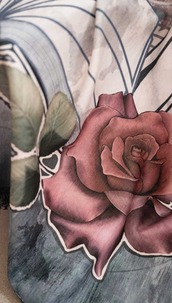 Zoomed in image of chenille WERKSHOP Tapestry with original bookish artwork. There is a tombstone with the phrase, "Read in Peace" and "Famous last words: just one more chapter" .. The bottom of the tombstone has an open book with roses framing the base.