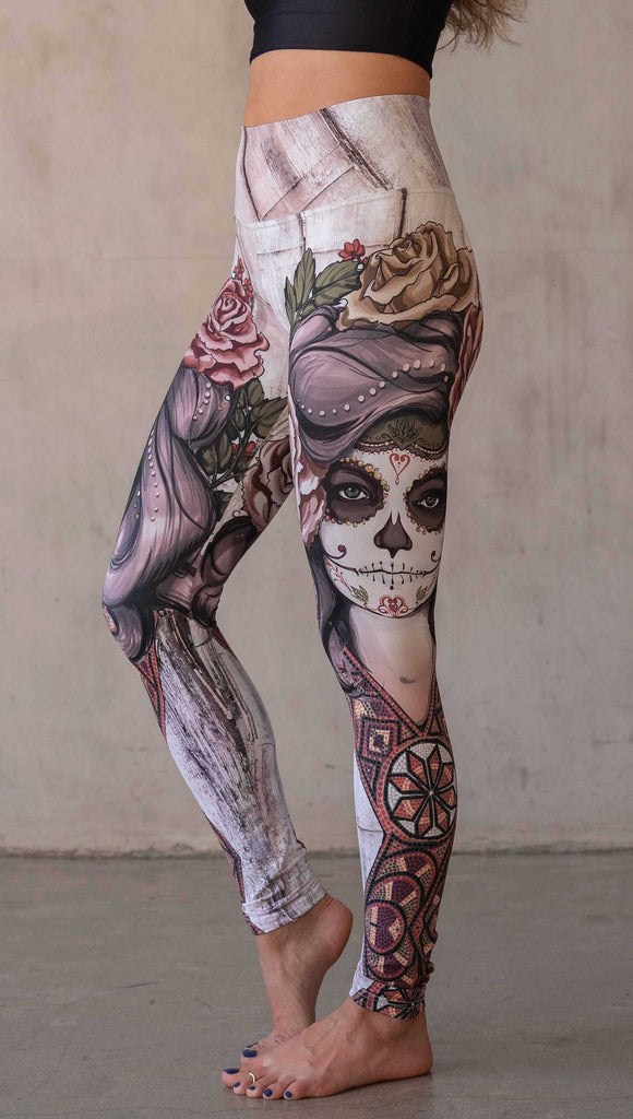 Girl wearing WERKSHOP "Remix" SugarSkull Athelisure leggings. The artwork printed on the leggings features a girl wearing Dia De Los Muertos makeup with a crown of roses and a beaded necklace with a romantic color woodgrain background.