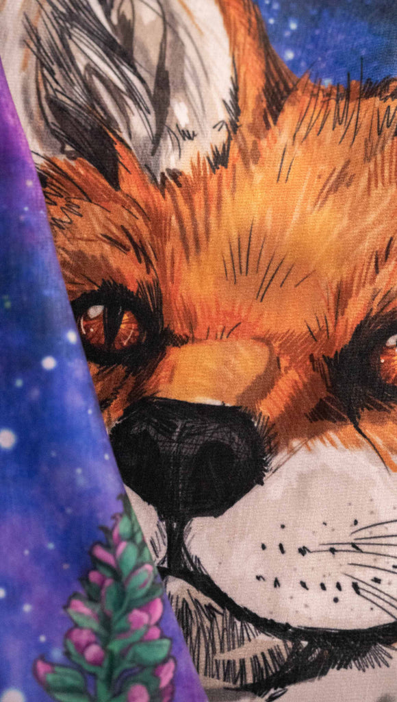 WERKSHOPs Save A Fox Tapestry. The tapestry features soft chenille fabric, with original artwork of a fox in front of a galactic background with foxglove plants framing him.