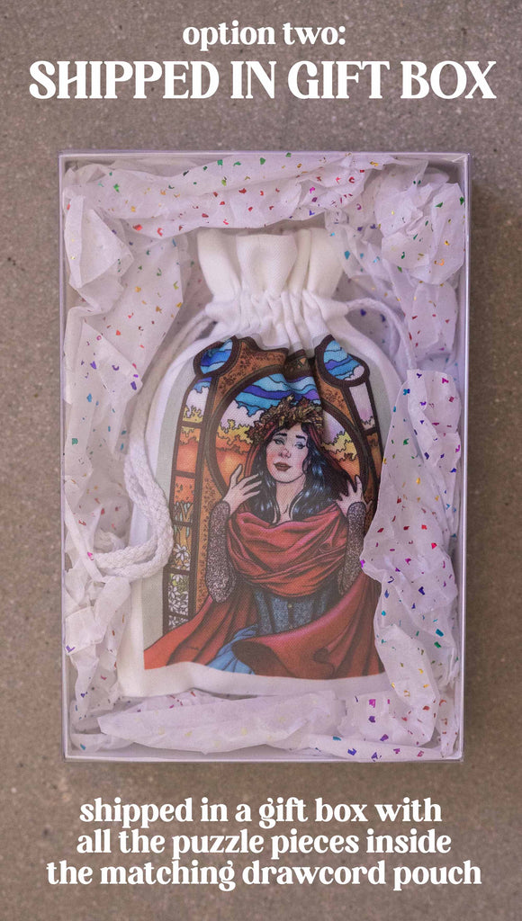 Art Nouveau Puzzle featuring original artwork by Scott Christian Sava. The painting features a woman with a cloak and crown of autumn leaves standing in front of a stained glass window. Option 2; shipped in a gift box with all the puzzle pieces inside the matching drawcord pouch