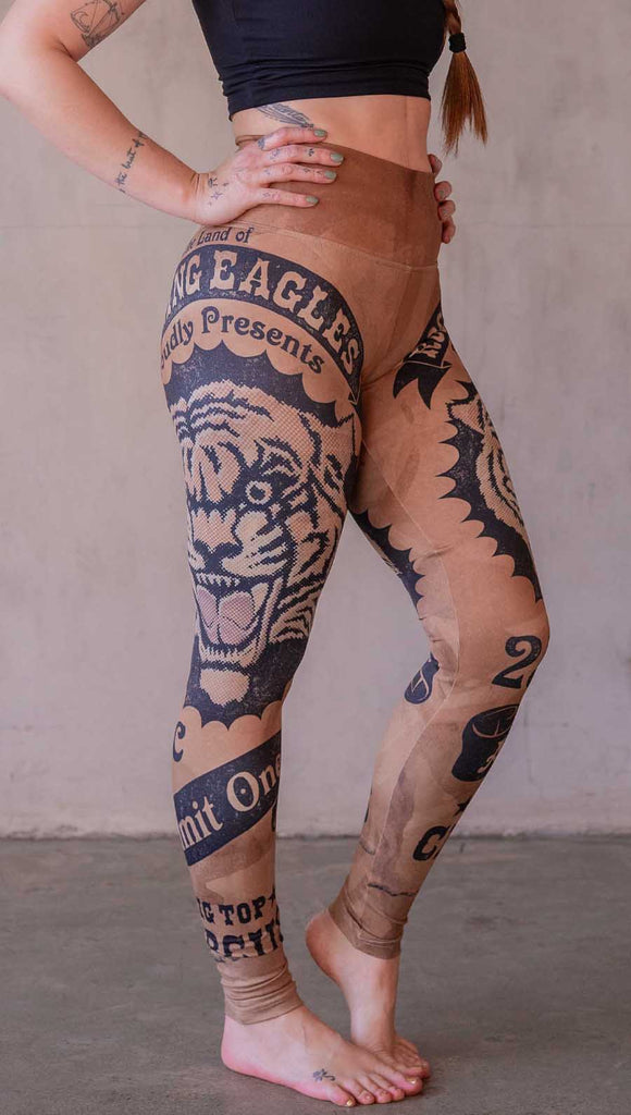 Model wearing WERKSHOP Tiger Ticket leggings featuring original and exclusive artwork depicting a vintage ticket to the circus! With a black sketch of a tiger over a distressed burnt orange background. 