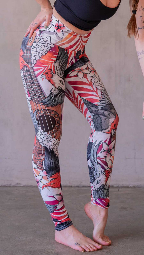 Model wearing WERKSHOP Ukulele leggings featuring original and exclusive artwork of a Ukulele and tropical birds with flower lei and bright palm fronds. 
