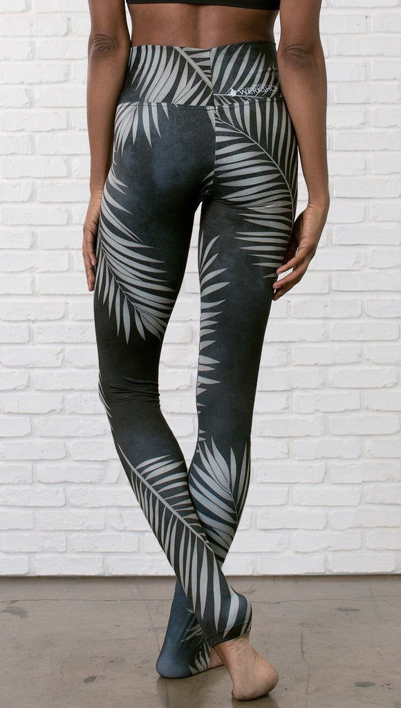 close up back view of model wearing full length black leggings with white palm design