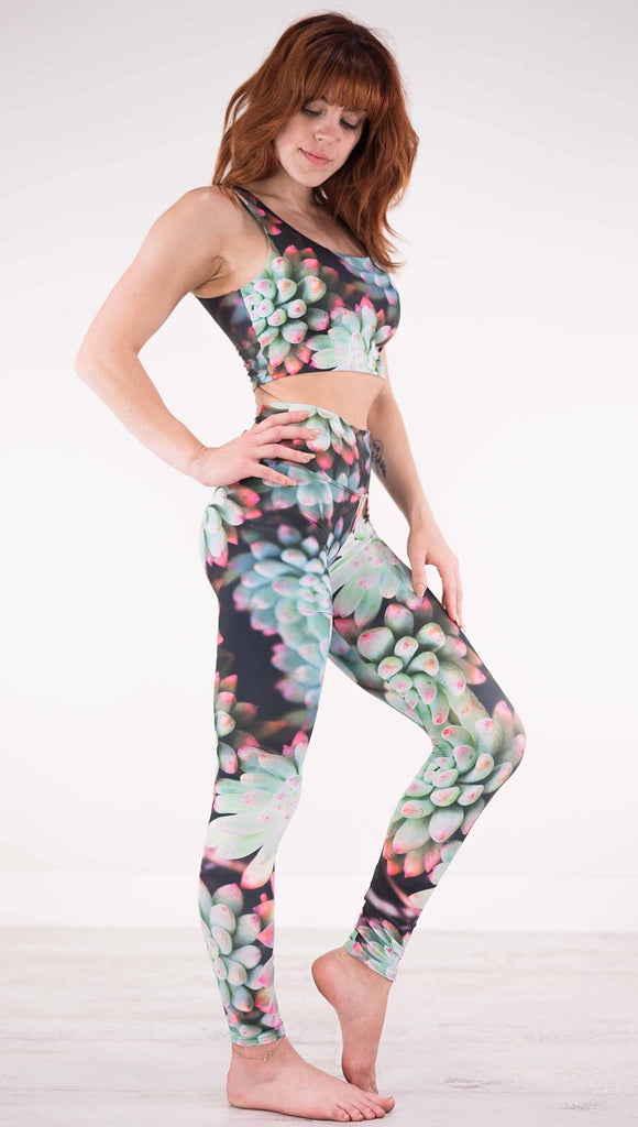 Right view of model wearing black athleisure leggings with green succulent plants with pink tips throughout