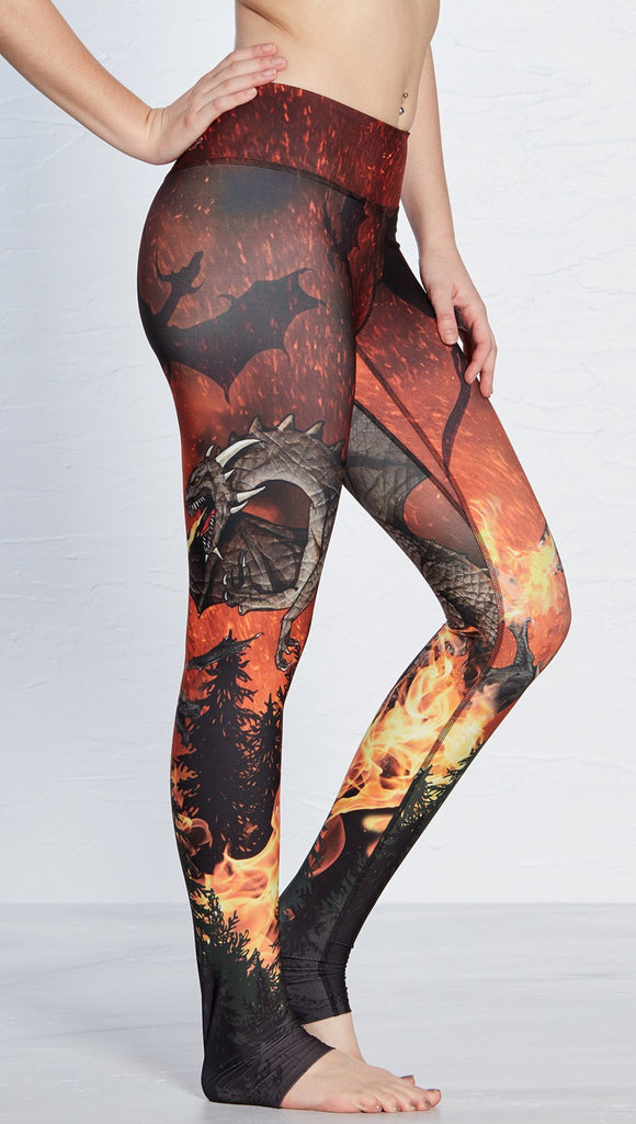 closeup right side view of model wearing fire breathing dragon themed printed full length leggings 