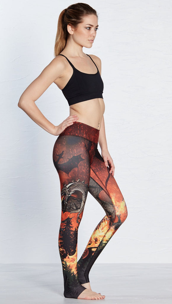 right side view of model wearing fire breathing dragon themed printed full length leggings 