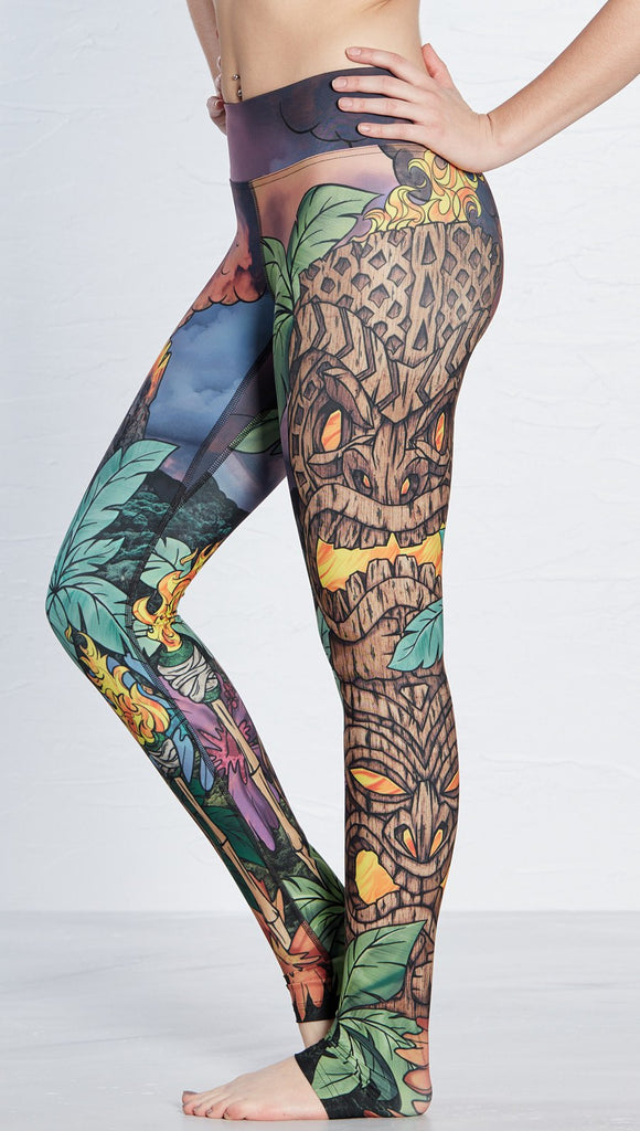 close up left side view of model wearing island tiki themed printed full length leggings