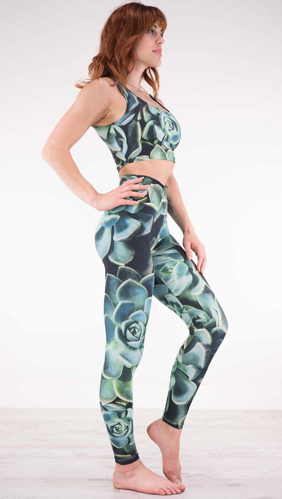 Right view of model wearing black athleisure leggings with green succulent plants throughout