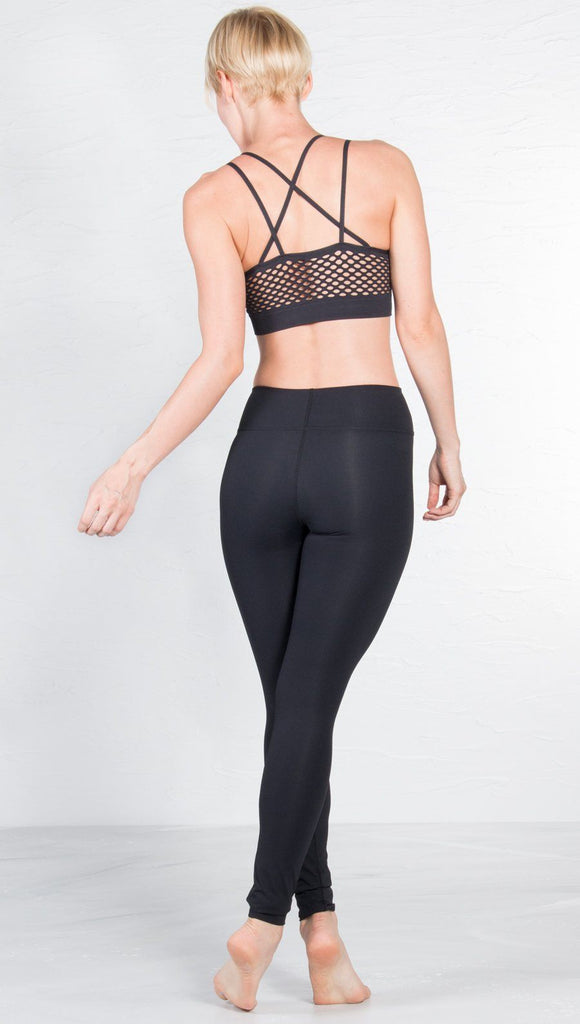 back view of model wearing black sports bra with matching leggings
