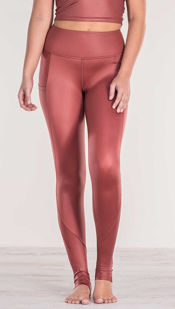 Close up front view of model wearing shiny mauve full length leggings with right side pocket