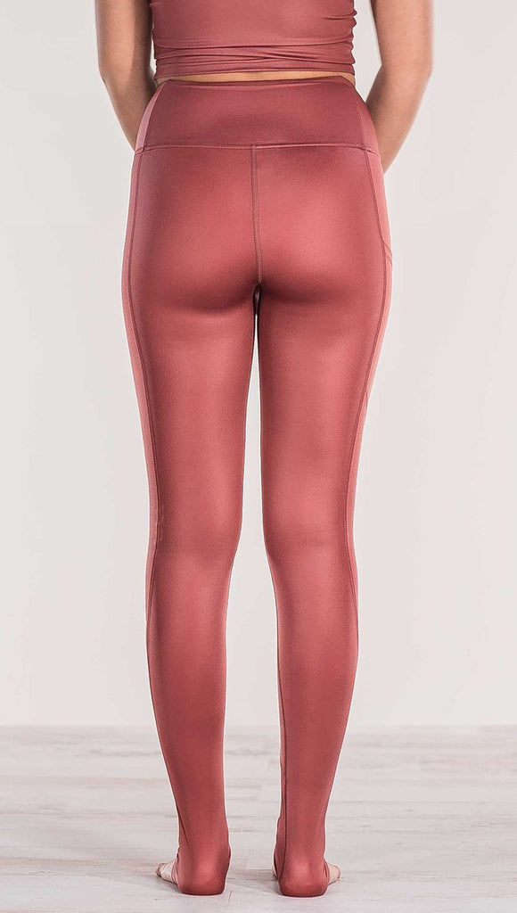 Close up rear view of model wearing shiny mauve full length leggings with right side pocket