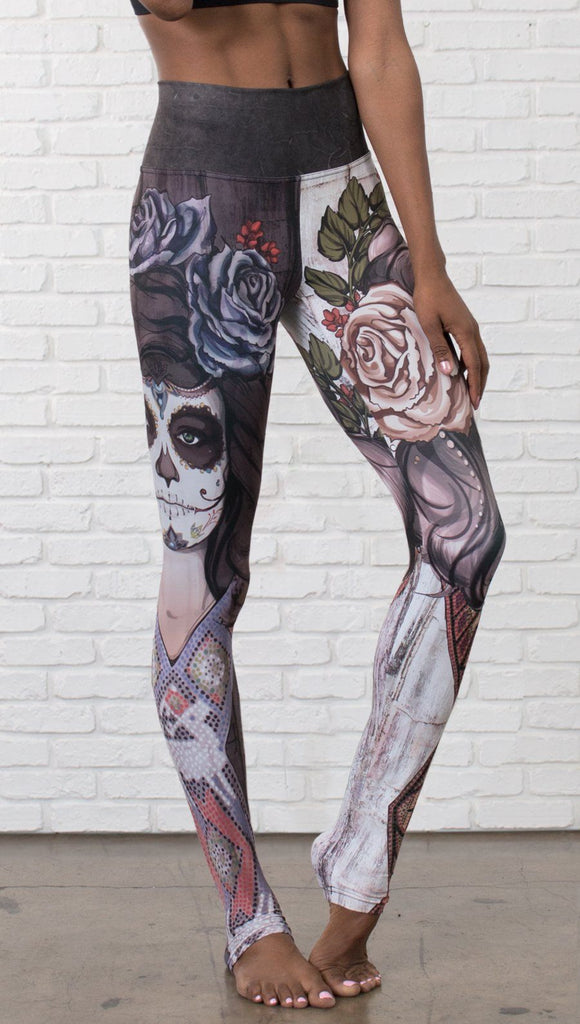 closeup front view of model wearing mashup Sugar Skull and Dia De Los Muertos themed printed full length leggings