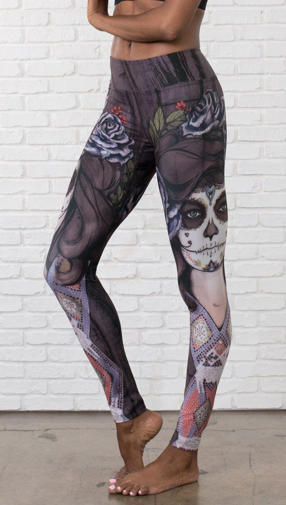 close up left side view of model wearing sugar skull themed printed full length leggings