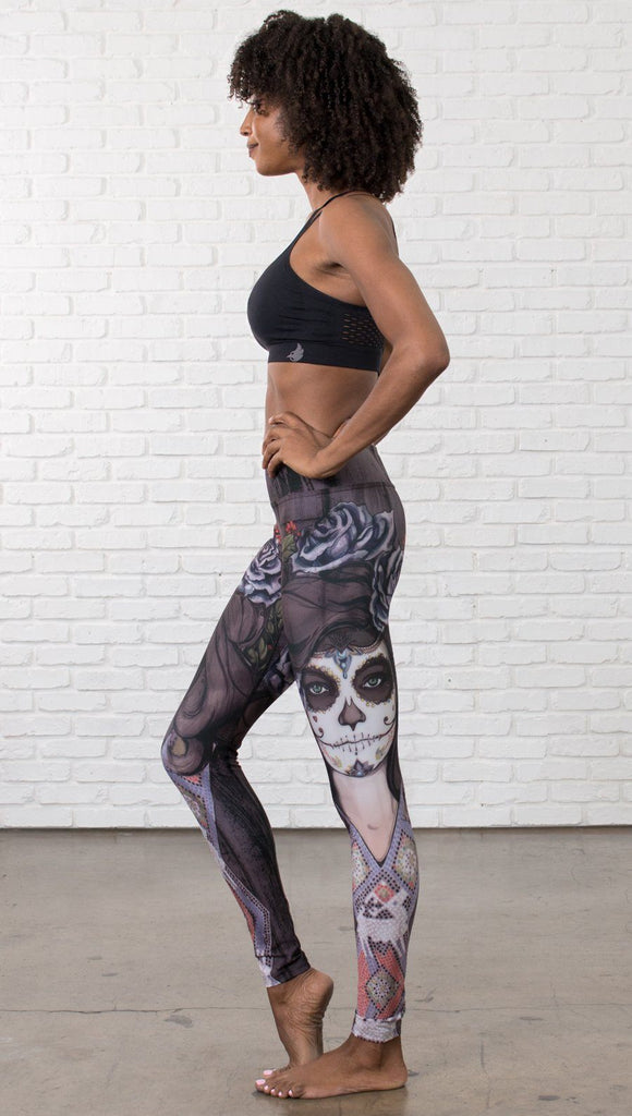 left side view of model wearing sugar skull themed printed full length leggings