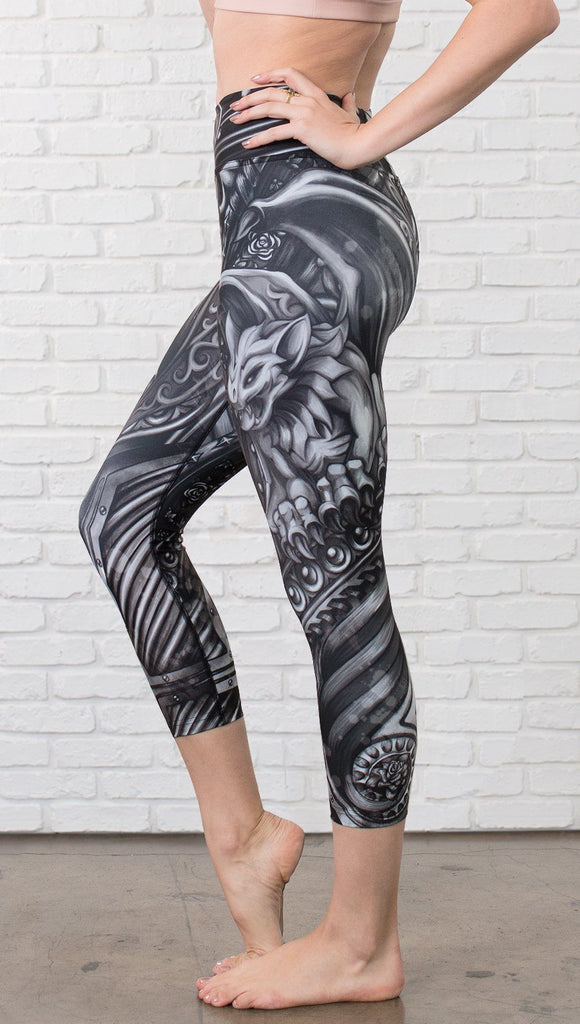 closeup left side view of model wearing gothic themed printed capri leggings