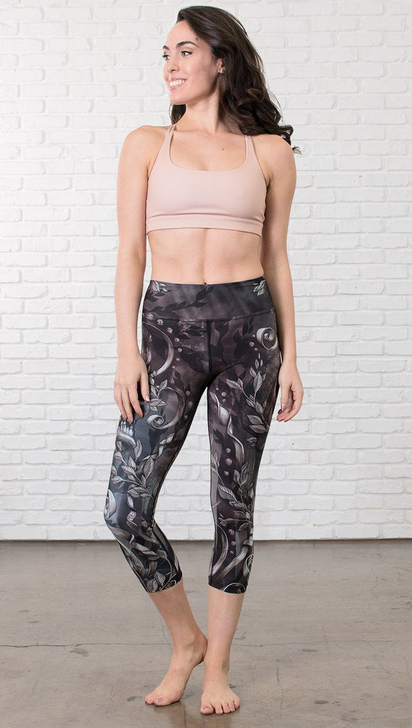 front view of model wearing gothic themed printed capri leggings