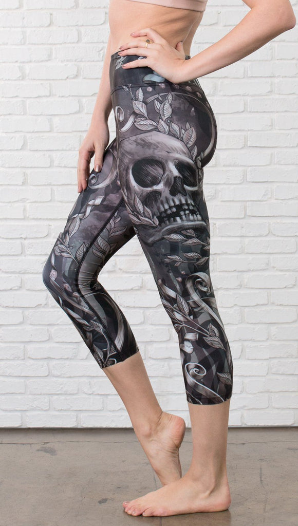 close up left side view of model wearing gothic themed printed capri leggings