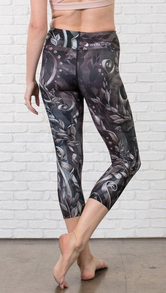 close up back view of model wearing gothic themed printed capri leggings