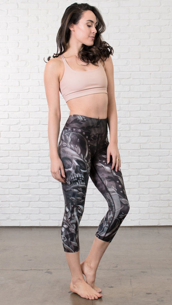 front view of model wearing gothic themed printed capri leggings