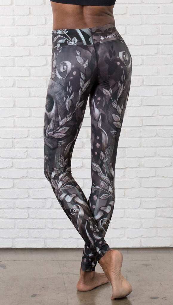 close up back view of model wearing gothic themed printed full length leggings